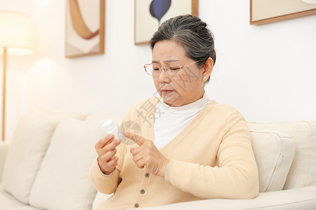 老奶奶坐沙发上看药品说明高清图片