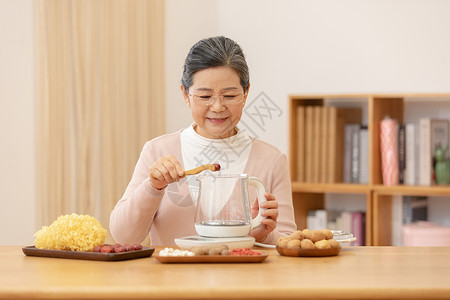 老奶奶居家养生煮银耳汤夹红枣特写高清图片