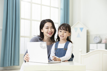 互联网教育用图妈妈陪着女儿用笔记本电脑上网课背景