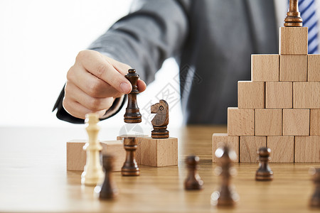 定价策略商务男士手拿国际象棋背景