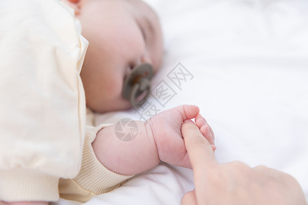 婴儿睡觉抓着妈妈的手高清图片