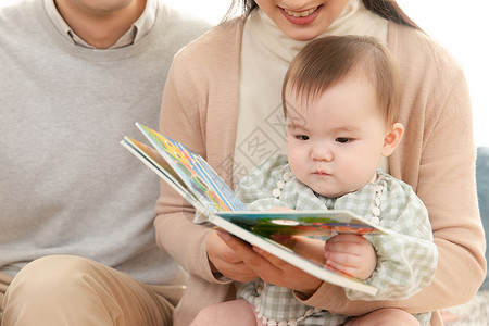 爸爸妈妈给婴儿看书讲故事图片素材