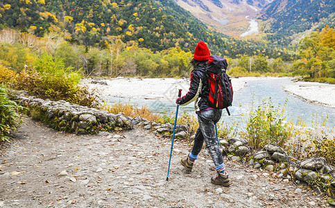 背包爬山在日本阿尔卑斯山徒步旅行的女人背景