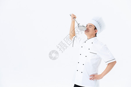 男厨师拿着汤勺品尝菜品背景图片