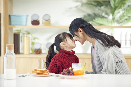 年轻妈妈和女儿吃早餐互动高清图片
