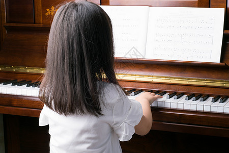 快速培训开启学弹钢琴的女孩背景