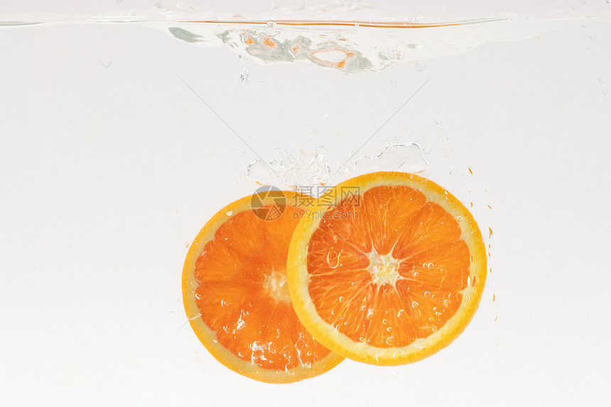 掉落水中的橙子水果切片图片