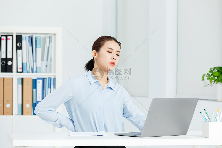 青年商务女性办公室工作劳累腰疼图片