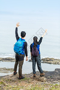 野外海边背包男女挥手背景图片