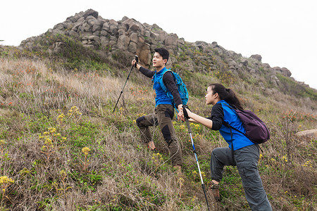 拉手男女户外登山中的情侣背景