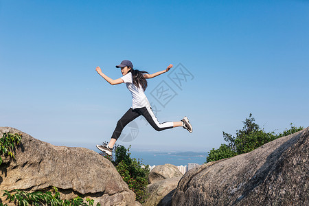 石头上美女郊外石头上跳跃中的美女背景