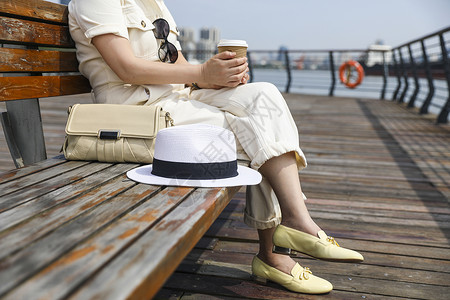 坐在江边看风景喝咖啡的时尚美女图片