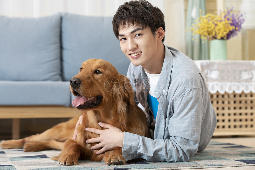 与金毛相伴的居家男孩图片