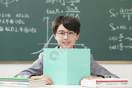 坐着课桌上看书的男孩中国人高清图片素材