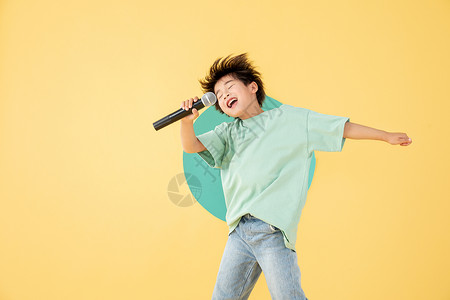 活泼的小孩拿话筒唱歌的男孩背景