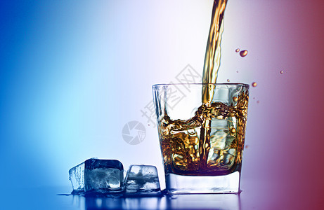 xo酒倒入加冰块的酒杯中溅起酒花的洋酒背景