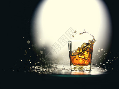 xo酒倒入加冰块的酒杯中溅起酒花的白兰地背景