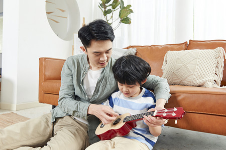 父亲和孩子在家一起玩乐器高清图片