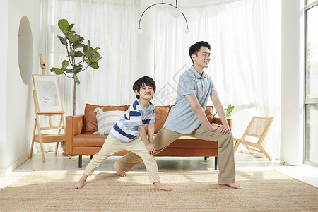 爸爸和孩子在客厅锻炼身体高清图片