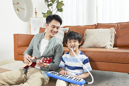 父亲和孩子在家一起玩乐器高清图片