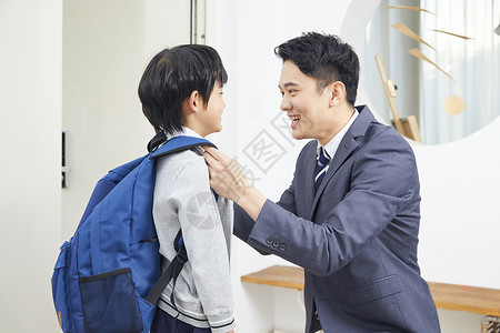 父亲载小孩上学爸爸给儿子整理服装背景