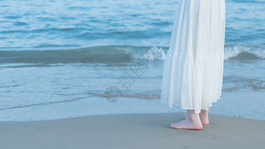 赤脚的赤脚站在海边沙滩上背景