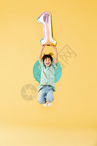 手举气球跳跃的小男孩图片