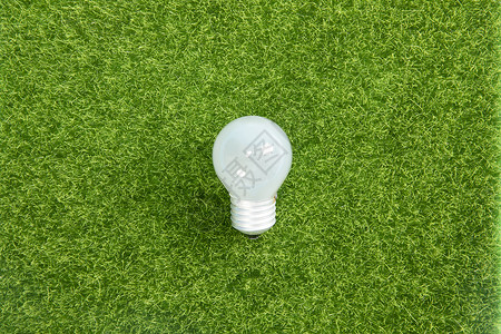 生态资源节能灯泡与绿色草坪背景