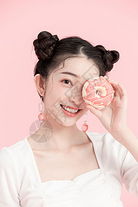 用甜甜圈遮眼睛的女孩图片