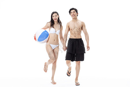 夏日泳装情侣拿着沙滩排球图片