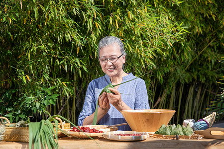 端午节户外奶奶包粽子图片