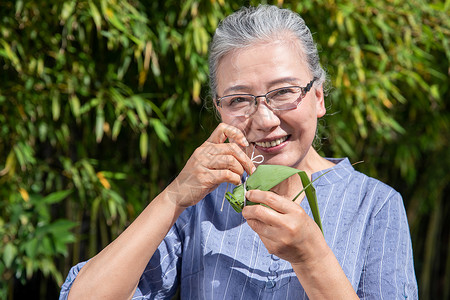 端午节户外奶奶包粽子图片