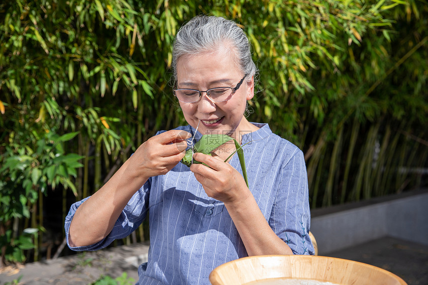 端午节户外奶奶包粽子图片