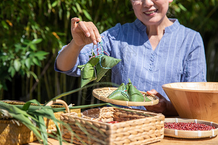 端午节奶奶户外拿着粽子图片