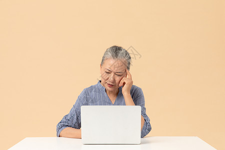 老年女性用笔记本电脑烦恼背景图片