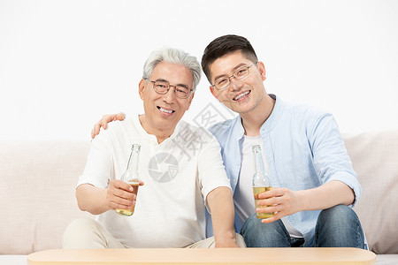 中老年父子沙发上喝啤酒高清图片