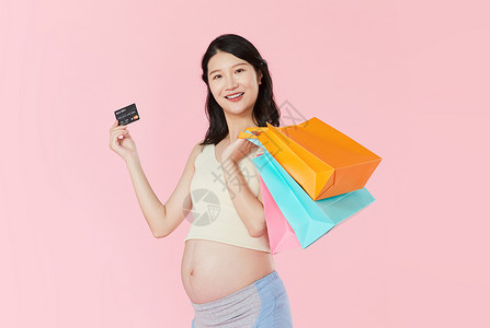 孕妇手拿购物袋和信用卡图片