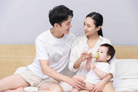 一家三口爸爸妈妈喂婴儿喝奶背景图片