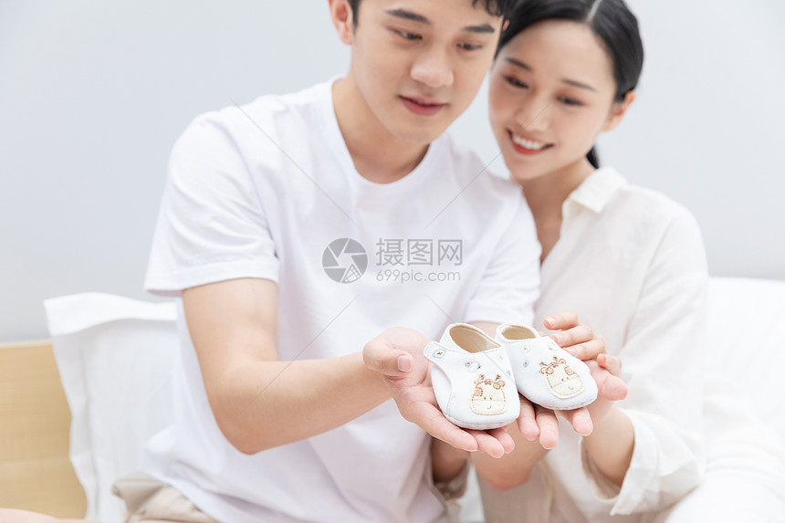 准爸爸准妈妈拿着婴儿鞋子图片