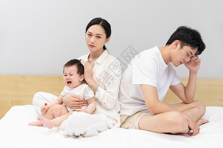 年轻的父母为哭泣的婴儿头疼背景图片