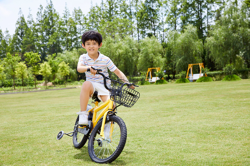 小男孩草坪上骑单车