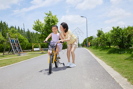 农村妈妈妈妈教小女孩骑单车背景