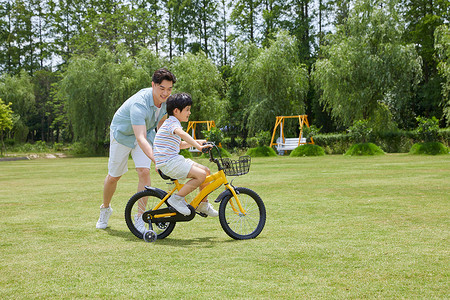 爸爸骑自行车爸爸陪伴小男孩骑自行车背景