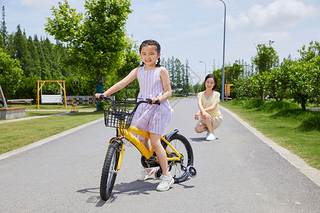 农村妈妈妈妈陪伴女儿骑自行车背景