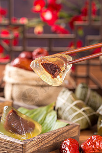 筷子夹起晶莹剔透的红豆冰心粽子背景图片