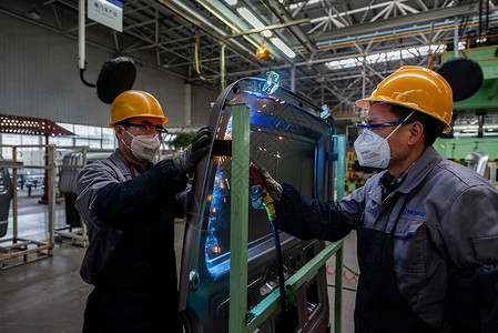 电焊工安全操作汽车生产线上作业的工人背景