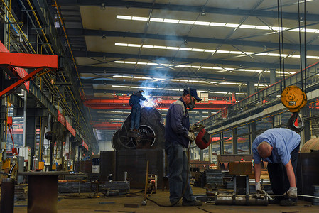 电焊工重工车间里在进行焊接的工人们背景