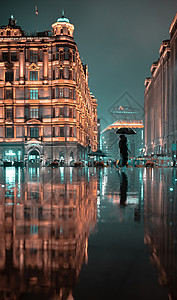 夜空下的伞雨中深夜的上海外滩街头背景