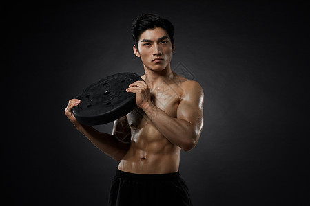 使用铁饼训练的健身男性背景图片