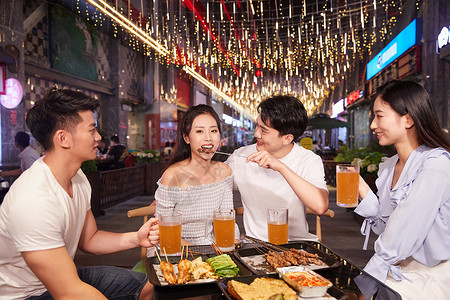 青年朋友聚会吃夜宵喝啤酒背景图片